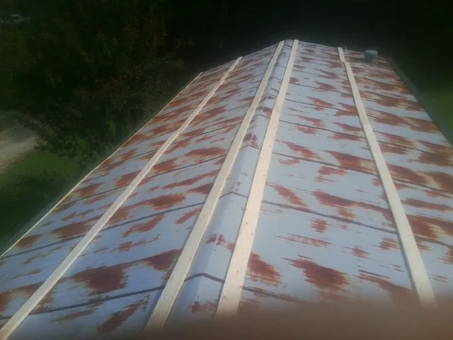 Rusted metal roof panels with new wood purlins before replacement — Storm Damage Roof Repair in Ellerslie by Roofing Brothers